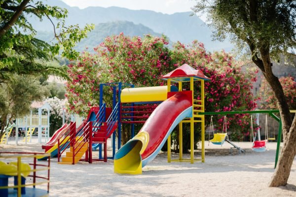 Children Playground in beautiful garden with mountains background